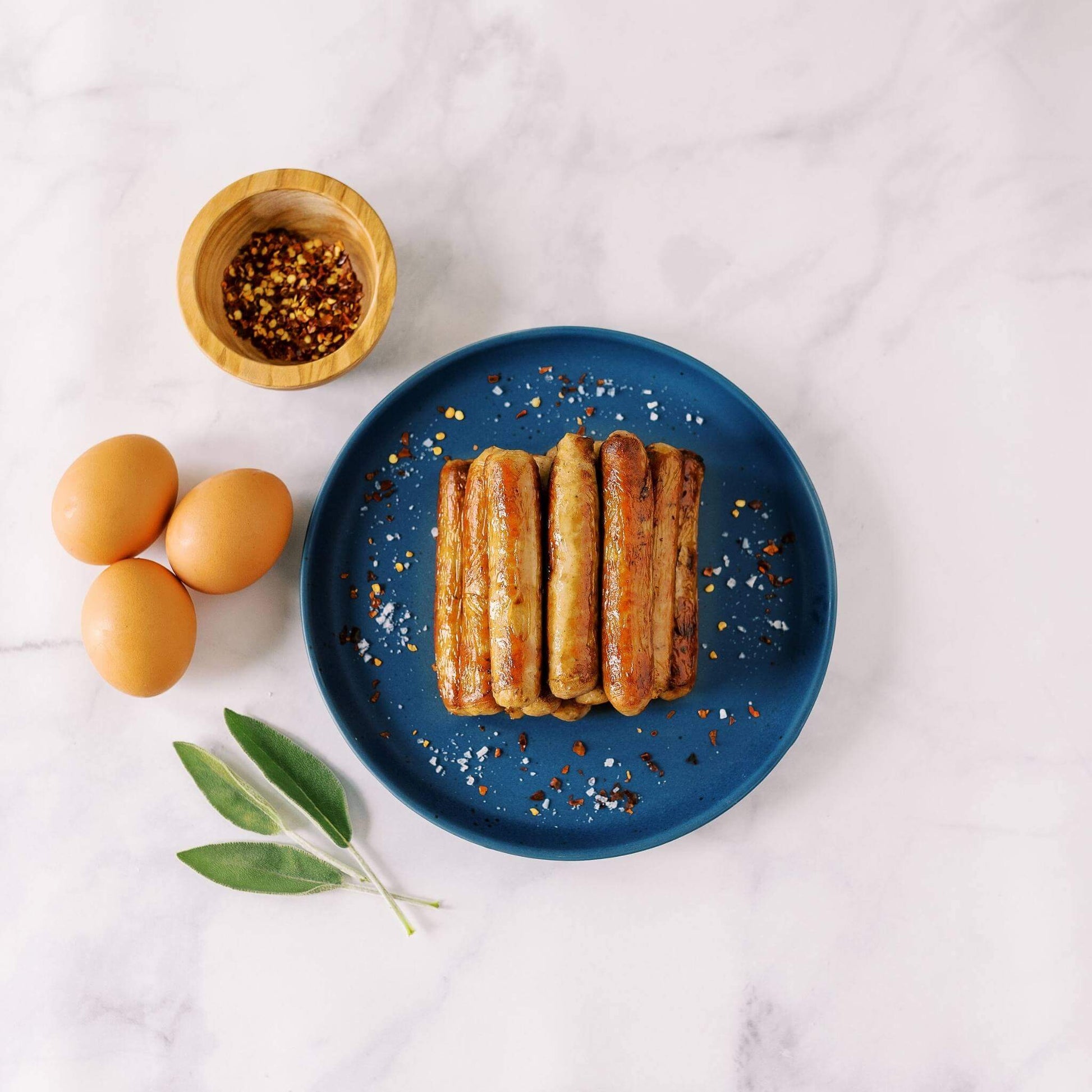 Cooked Pasture-raised sausage links on a blue plate