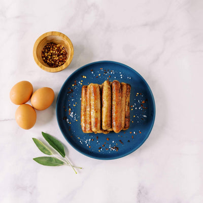 Cooked Pasture-raised sausage links on a blue plate